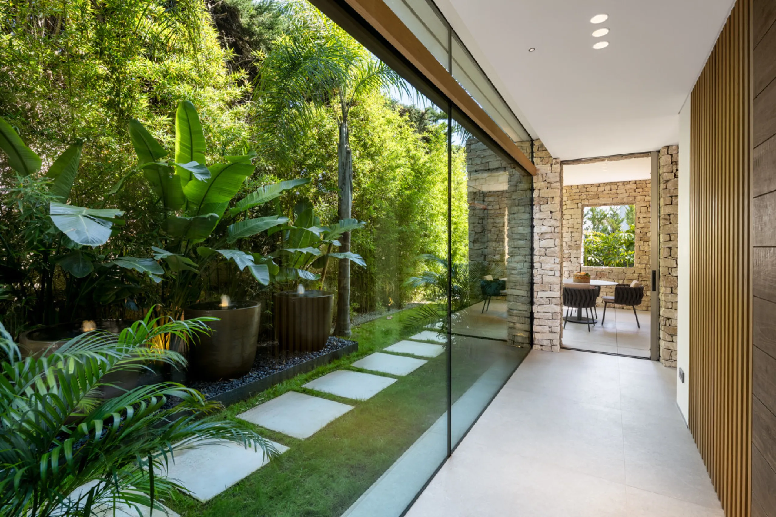Nestled gracefully upon the verdant slopes of Nueva Andalucía, this villa is a triumph of modern elegance and luxurious design, an embodiment of serene sophistication. As you approach the property, you are greeted by a grand entrance framed by sleek lines