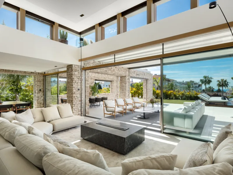 Nestled gracefully upon the verdant slopes of Nueva Andalucía, this villa is a triumph of modern elegance and luxurious design, an embodiment of serene sophistication. As you approach the property, you are greeted by a grand entrance framed by sleek lines