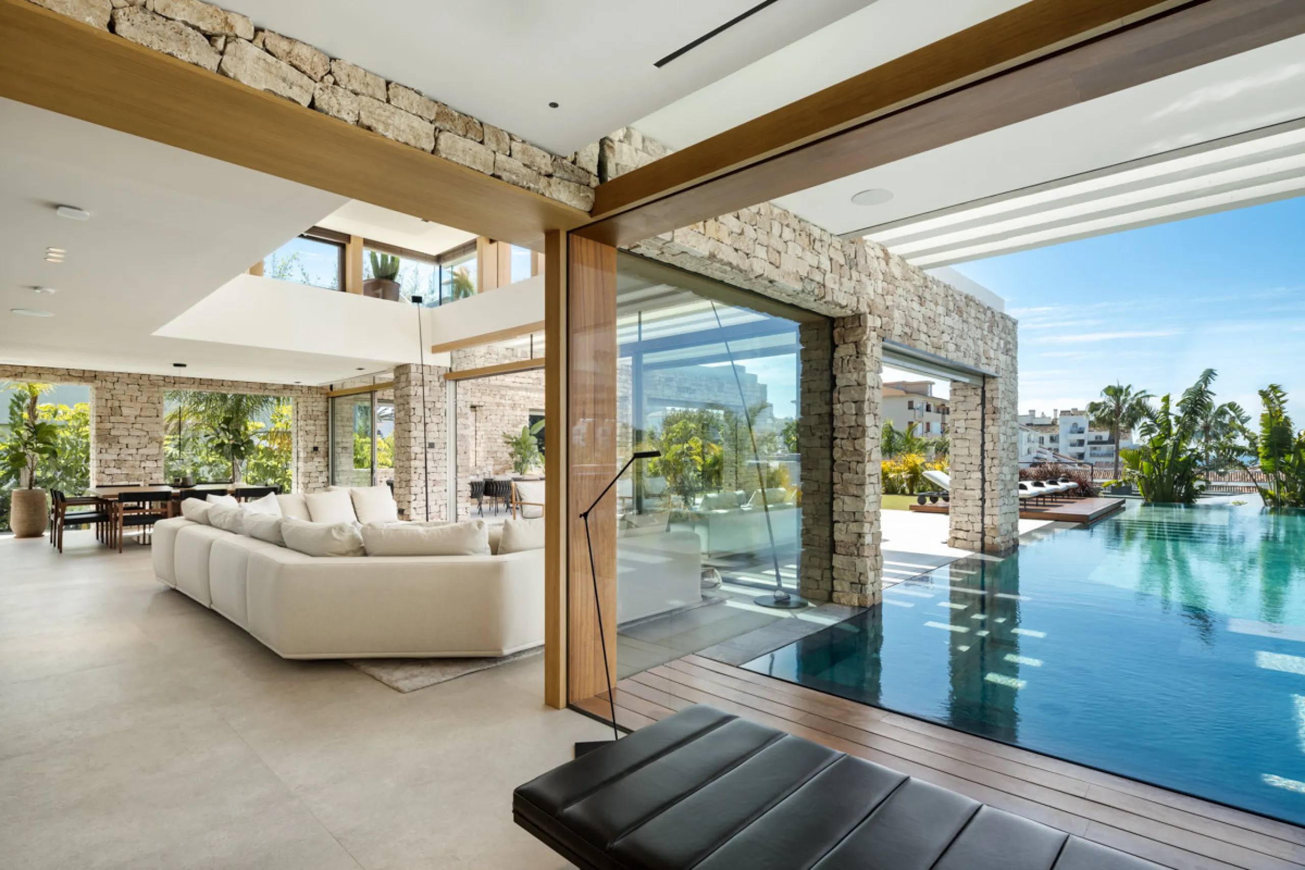 Nestled gracefully upon the verdant slopes of Nueva Andalucía, this villa is a triumph of modern elegance and luxurious design, an embodiment of serene sophistication. As you approach the property, you are greeted by a grand entrance framed by sleek lines