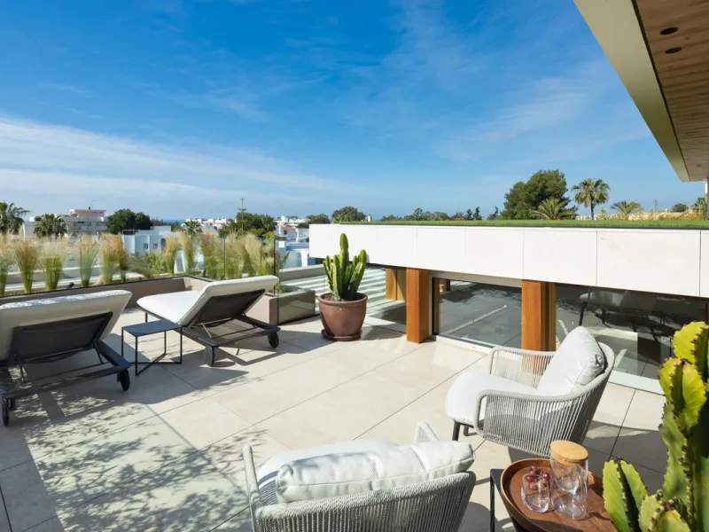 Nestled gracefully upon the verdant slopes of Nueva Andalucía, this villa is a triumph of modern elegance and luxurious design, an embodiment of serene sophistication. As you approach the property, you are greeted by a grand entrance framed by sleek lines