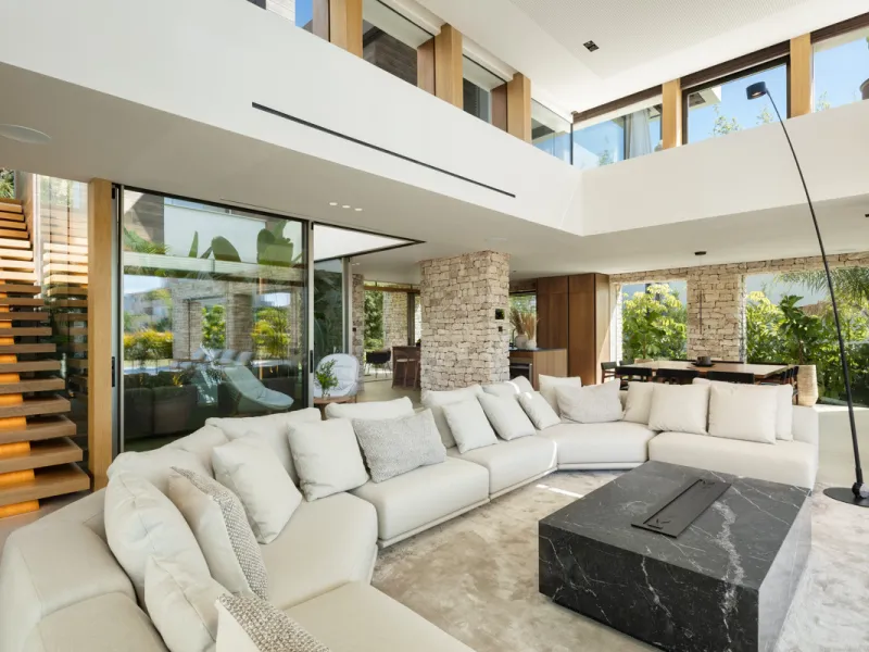Nestled gracefully upon the verdant slopes of Nueva Andalucía, this villa is a triumph of modern elegance and luxurious design, an embodiment of serene sophistication. As you approach the property, you are greeted by a grand entrance framed by sleek lines