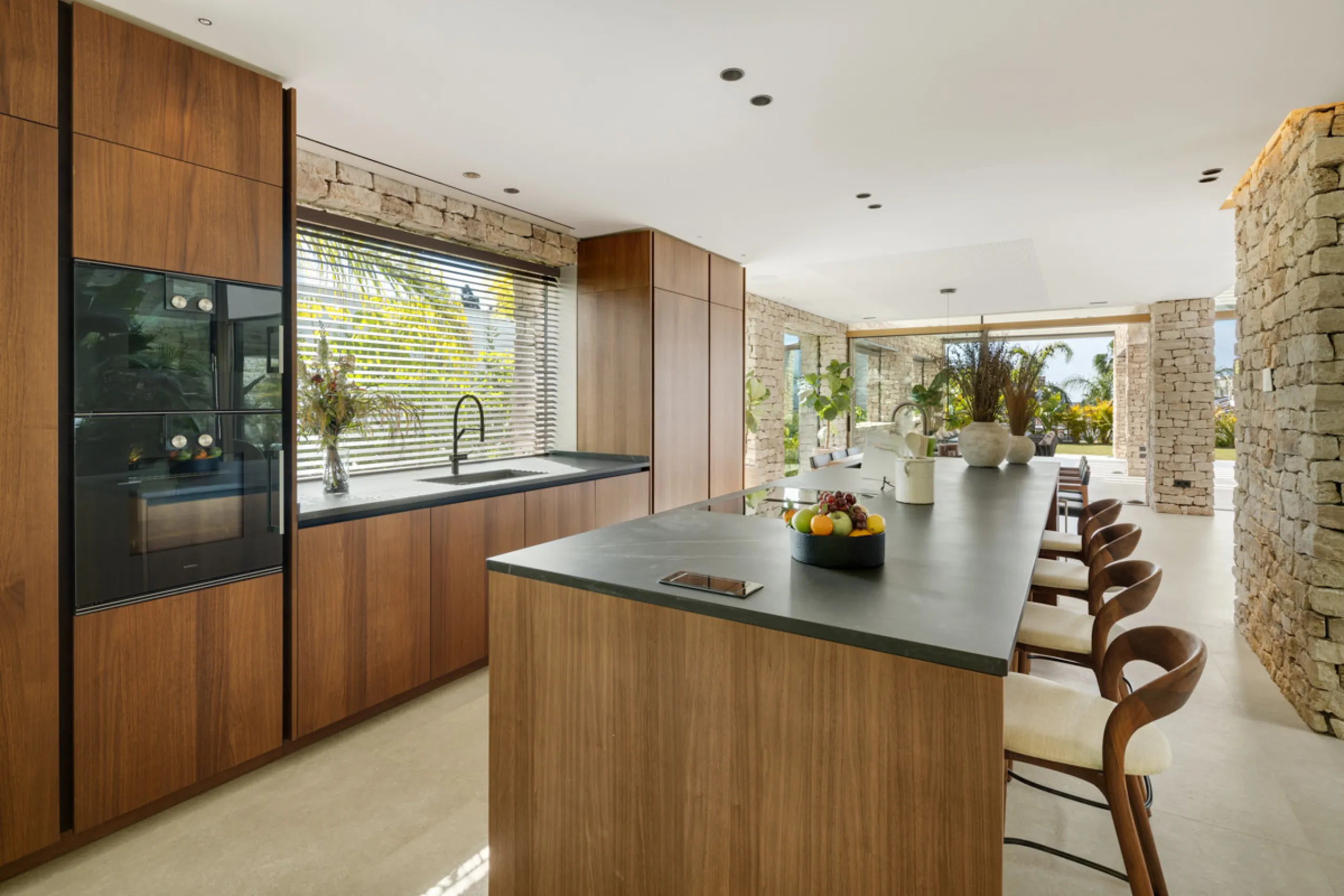 Nestled gracefully upon the verdant slopes of Nueva Andalucía, this villa is a triumph of modern elegance and luxurious design, an embodiment of serene sophistication. As you approach the property, you are greeted by a grand entrance framed by sleek lines
