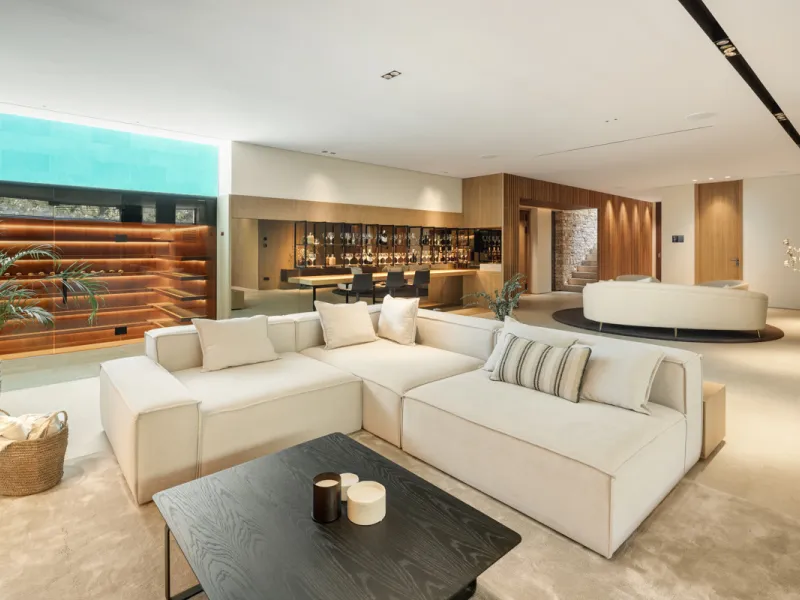 Nestled gracefully upon the verdant slopes of Nueva Andalucía, this villa is a triumph of modern elegance and luxurious design, an embodiment of serene sophistication. As you approach the property, you are greeted by a grand entrance framed by sleek lines