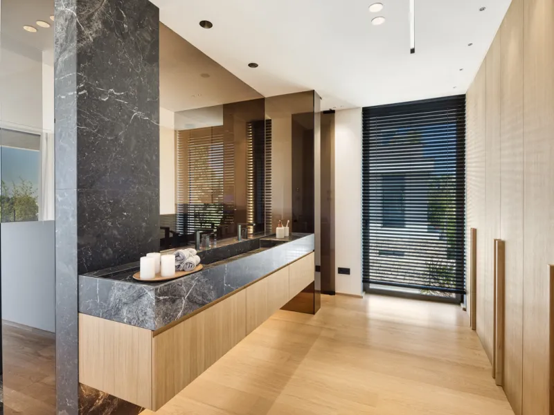 Nestled gracefully upon the verdant slopes of Nueva Andalucía, this villa is a triumph of modern elegance and luxurious design, an embodiment of serene sophistication. As you approach the property, you are greeted by a grand entrance framed by sleek lines