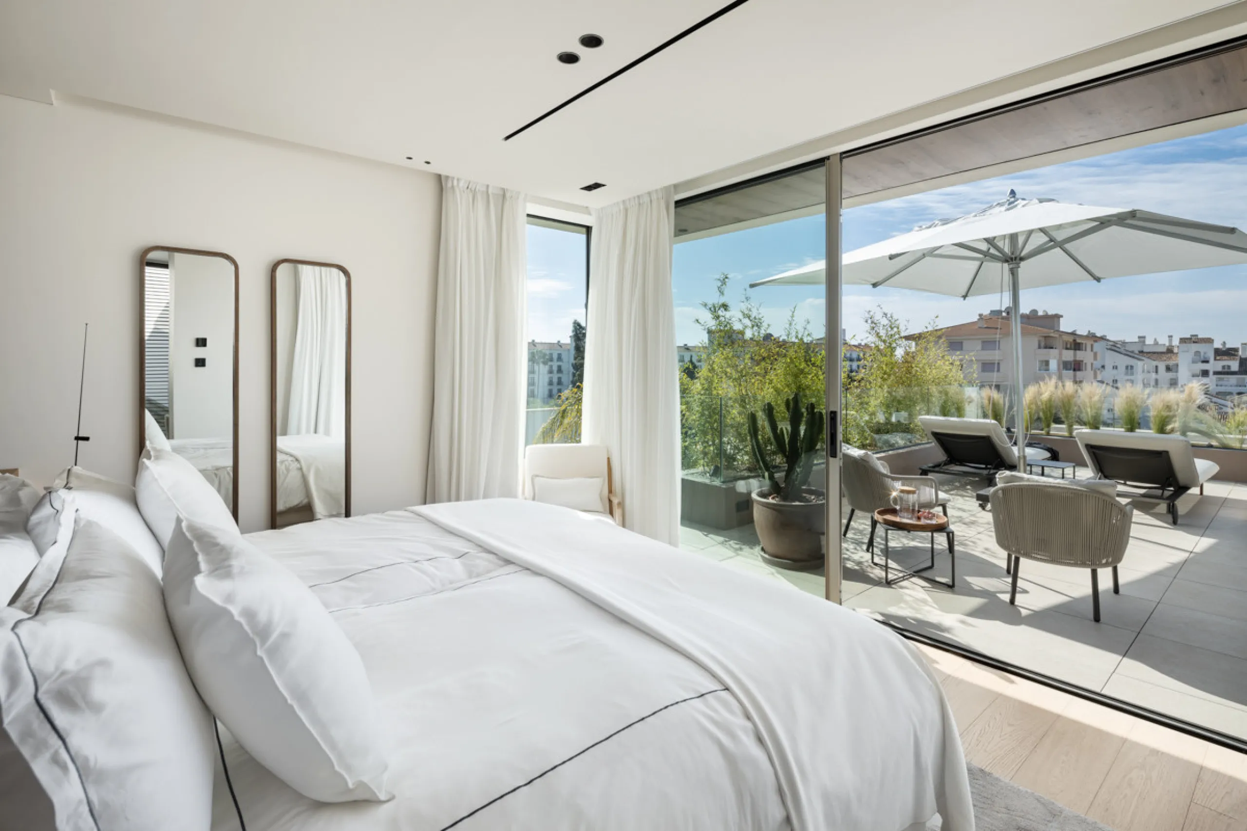 Nestled gracefully upon the verdant slopes of Nueva Andalucía, this villa is a triumph of modern elegance and luxurious design, an embodiment of serene sophistication. As you approach the property, you are greeted by a grand entrance framed by sleek lines