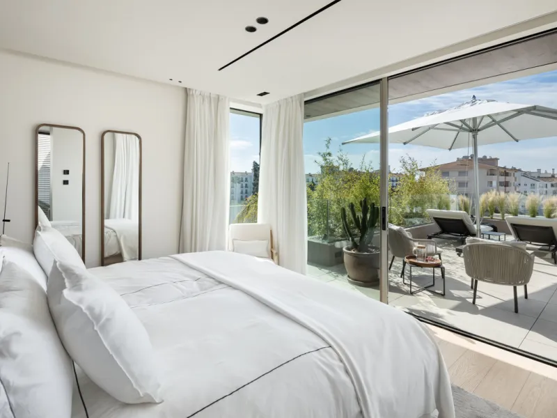 Nestled gracefully upon the verdant slopes of Nueva Andalucía, this villa is a triumph of modern elegance and luxurious design, an embodiment of serene sophistication. As you approach the property, you are greeted by a grand entrance framed by sleek lines