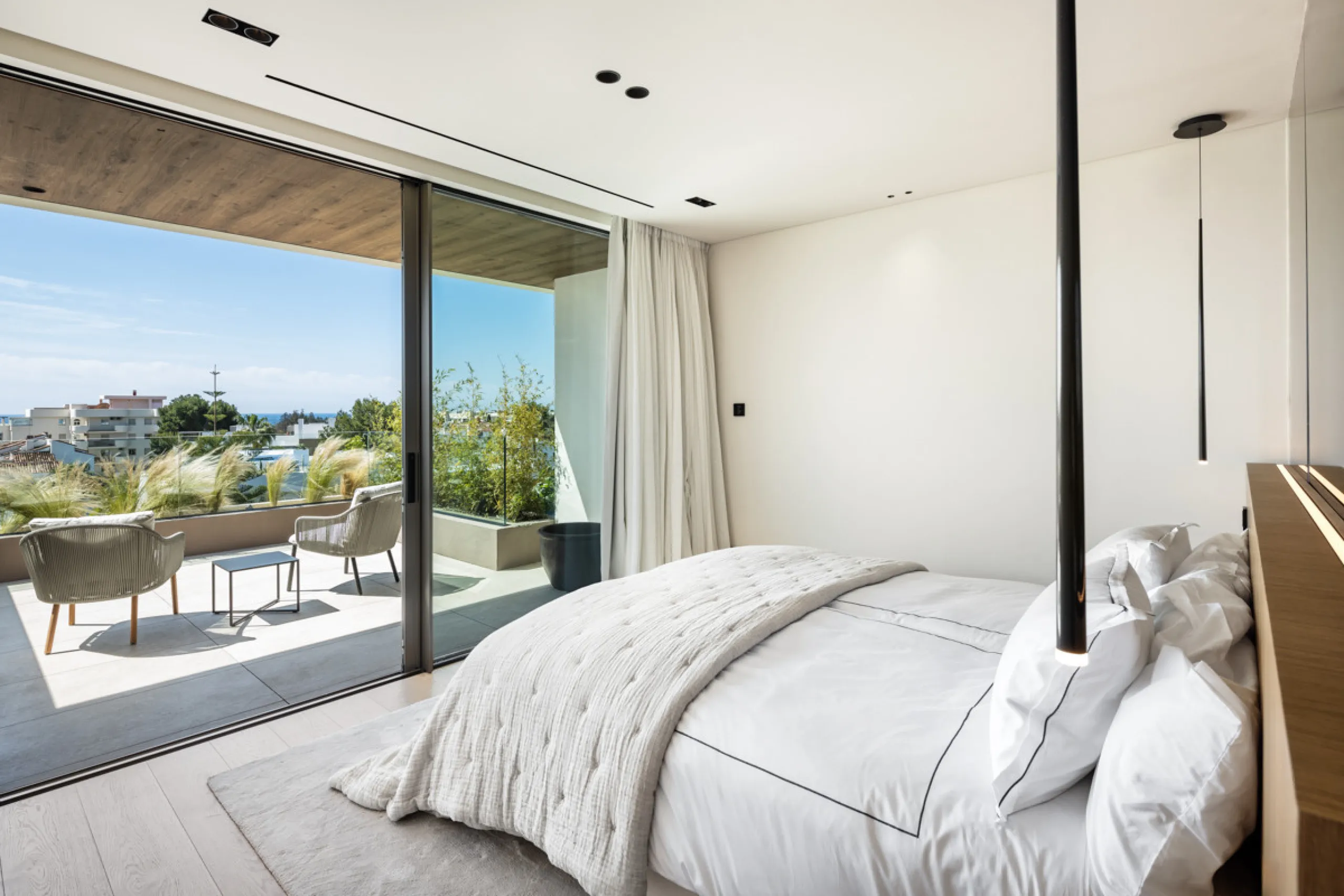 Nestled gracefully upon the verdant slopes of Nueva Andalucía, this villa is a triumph of modern elegance and luxurious design, an embodiment of serene sophistication. As you approach the property, you are greeted by a grand entrance framed by sleek lines