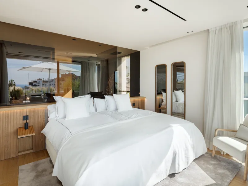 Nestled gracefully upon the verdant slopes of Nueva Andalucía, this villa is a triumph of modern elegance and luxurious design, an embodiment of serene sophistication. As you approach the property, you are greeted by a grand entrance framed by sleek lines