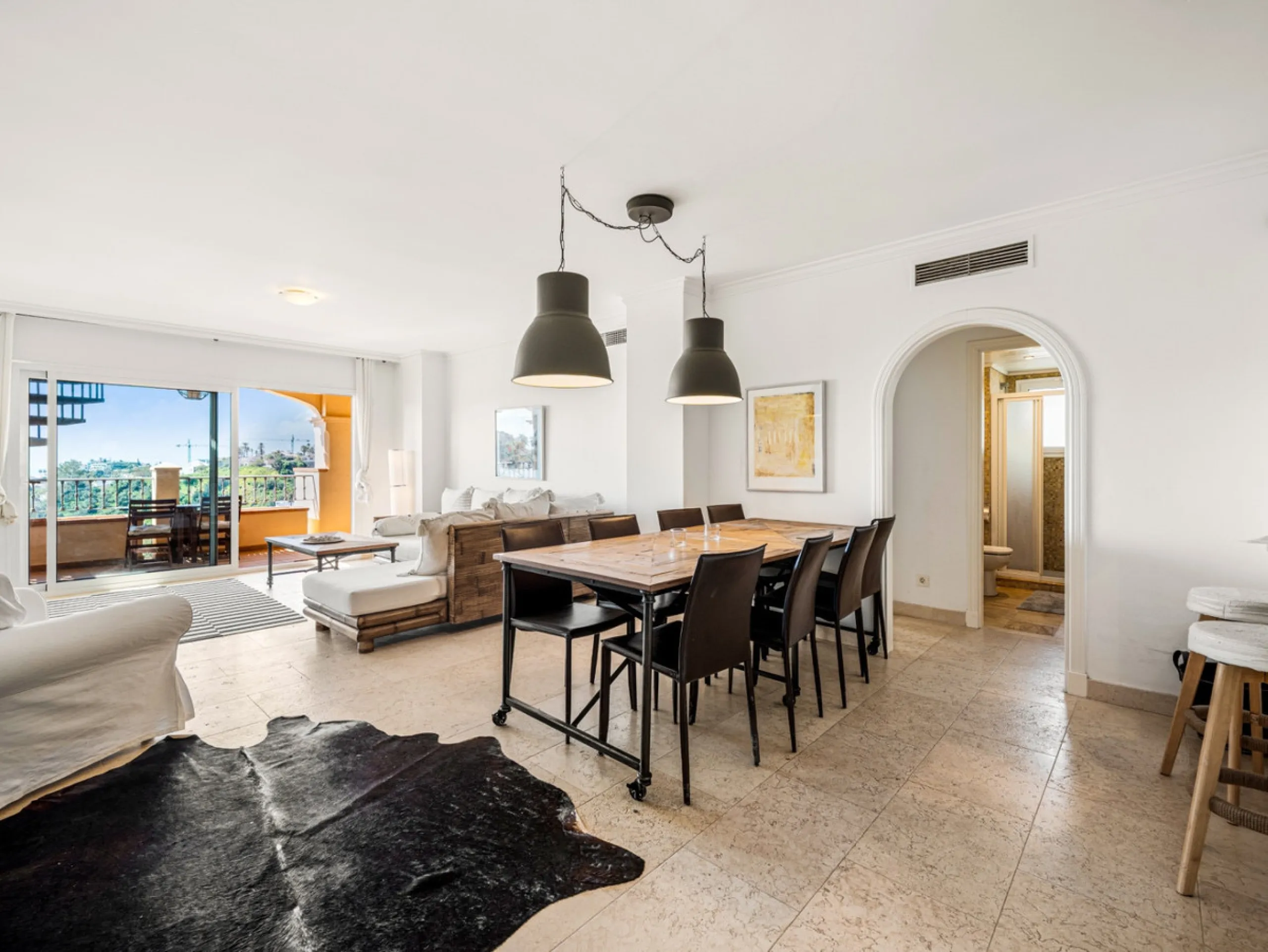 This penthouse is a 2 bedroom 2 bathroom duplex penthouse just 1 km from the beach. The home features open plan living spaces with bright interiors and large terrace windows. The kitchen overlooks the lounge and dining area through an elegant archway. The
