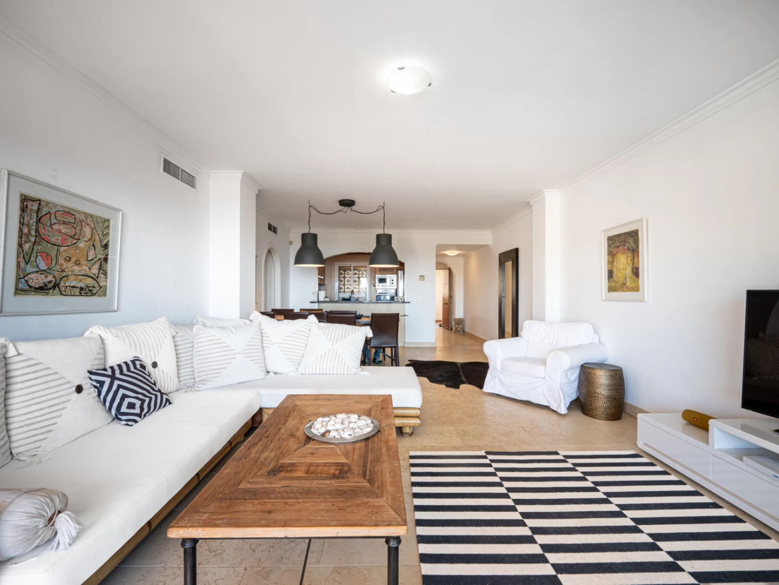 This penthouse is a 2 bedroom 2 bathroom duplex penthouse just 1 km from the beach. The home features open plan living spaces with bright interiors and large terrace windows. The kitchen overlooks the lounge and dining area through an elegant archway. The