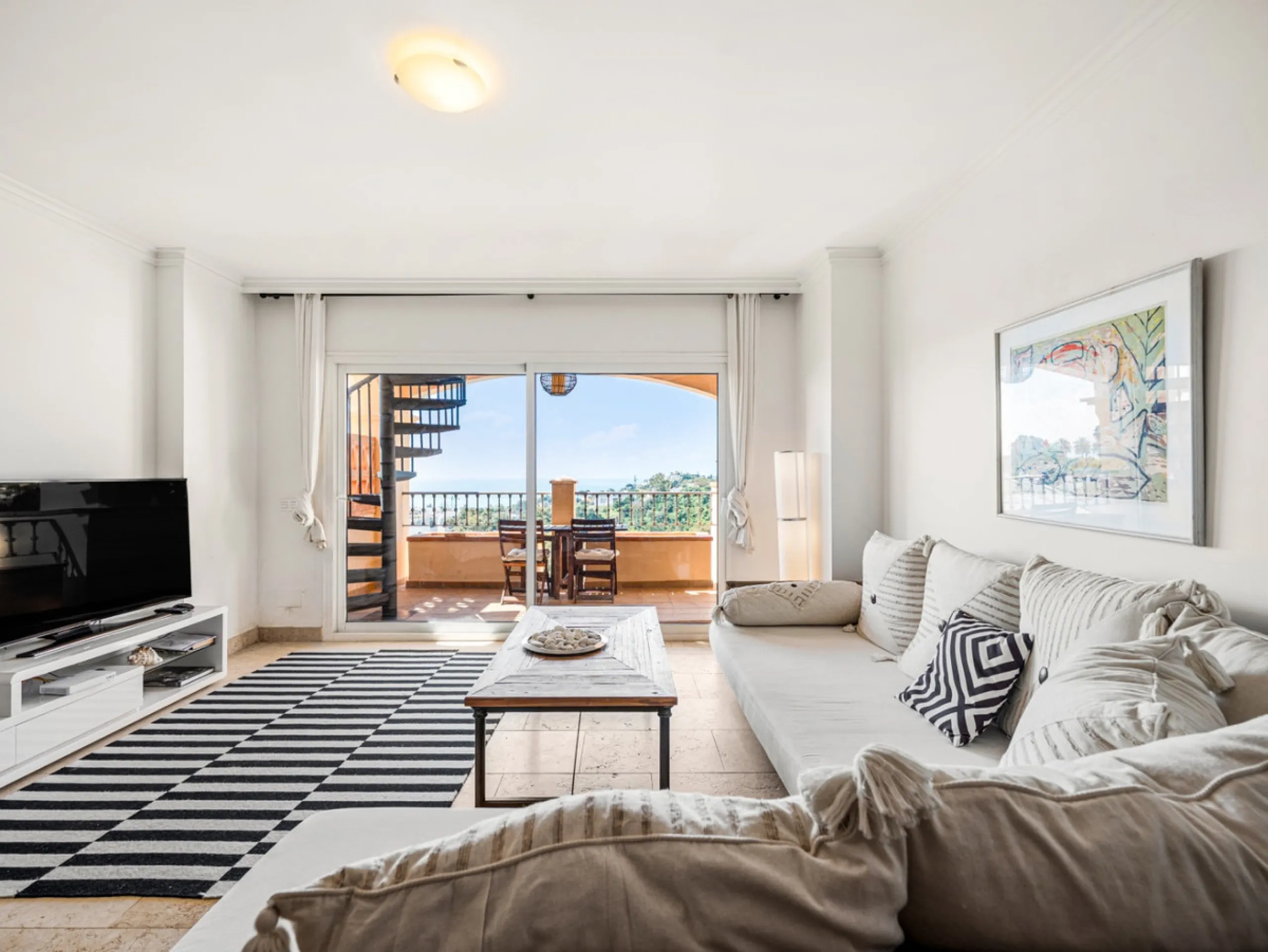 This penthouse is a 2 bedroom 2 bathroom duplex penthouse just 1 km from the beach. The home features open plan living spaces with bright interiors and large terrace windows. The kitchen overlooks the lounge and dining area through an elegant archway. The
