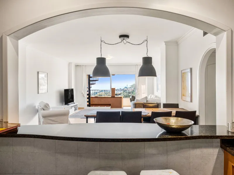 This penthouse is a 2 bedroom 2 bathroom duplex penthouse just 1 km from the beach. The home features open plan living spaces with bright interiors and large terrace windows. The kitchen overlooks the lounge and dining area through an elegant archway. The