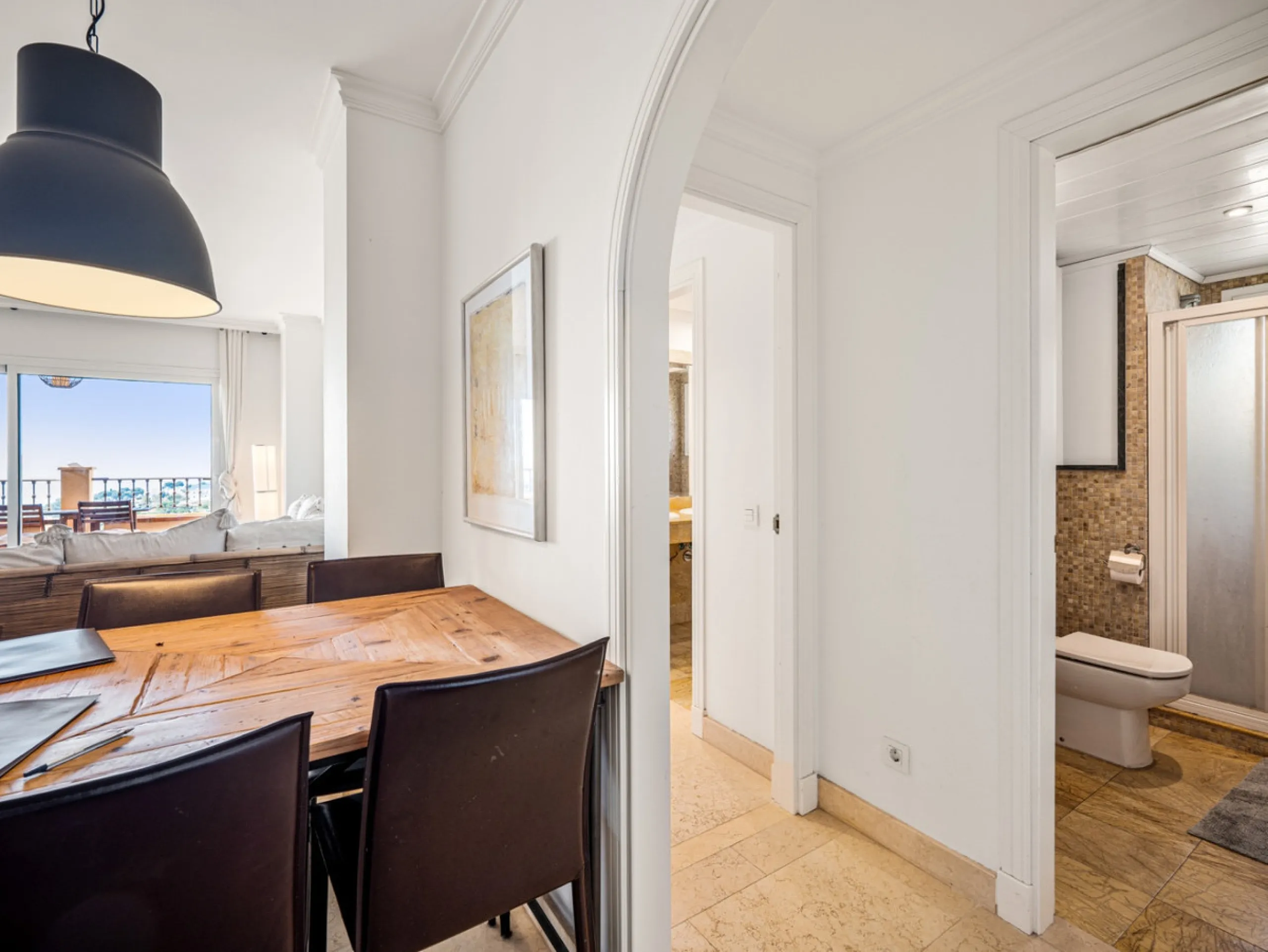 This penthouse is a 2 bedroom 2 bathroom duplex penthouse just 1 km from the beach. The home features open plan living spaces with bright interiors and large terrace windows. The kitchen overlooks the lounge and dining area through an elegant archway. The
