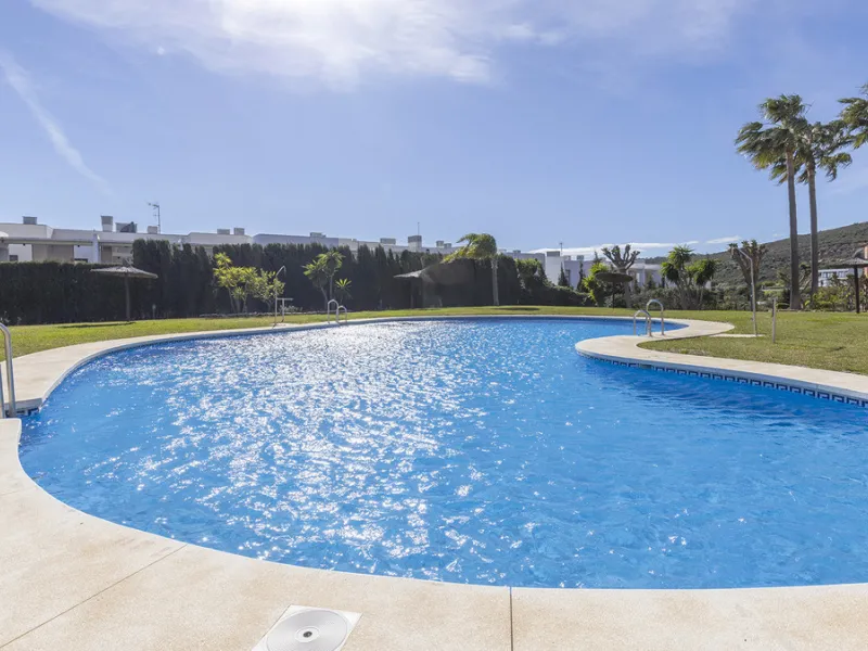 Situated in the established residential enclave of Bahía de las Rocas, this attractive three-bedroom ground floor apartment offers generous interior proportions and exceptional outdoor living.