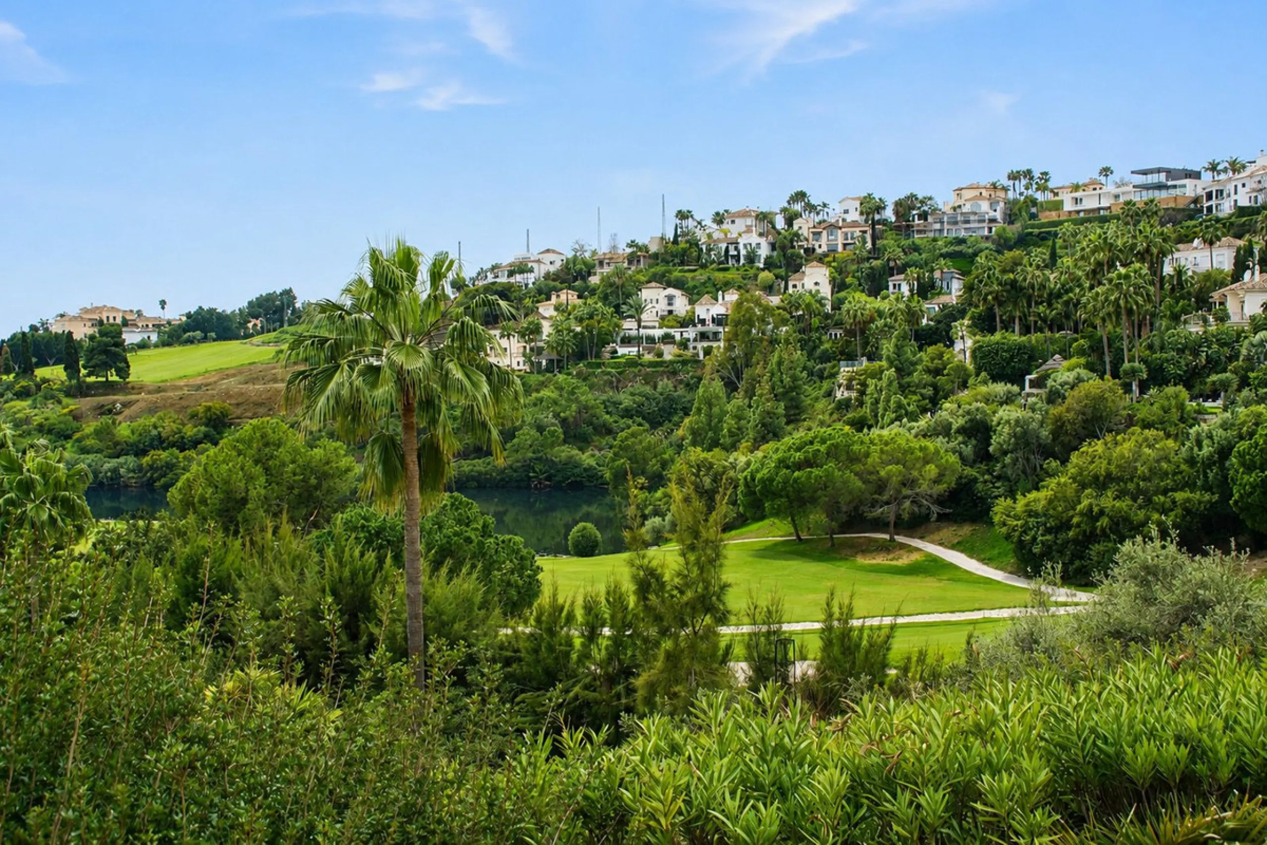 Ground floor apartment with private garden, open views, and 4 communal swimming pools.