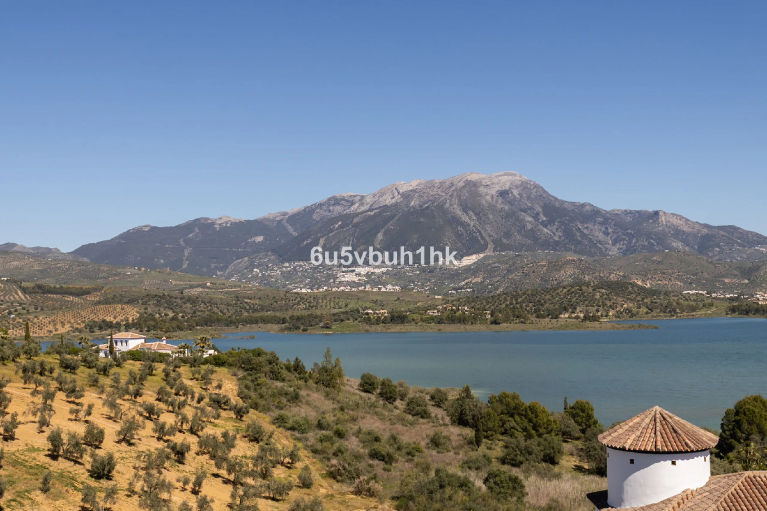 Some houses have a view. This one has a lake at its feet and a mountain range as its frame.