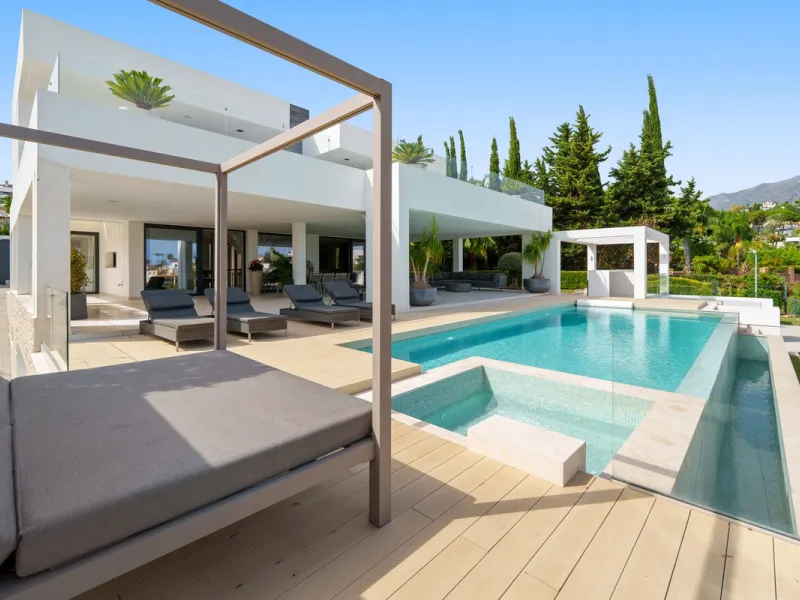 A striking contemporary villa in the heart of Nueva Andalucía, enjoying a privileged frontline golf position. With clean architectural lines, expansive terraces, and floor-to-ceiling windows, this home is designed to maximize natural light and uninterrupt