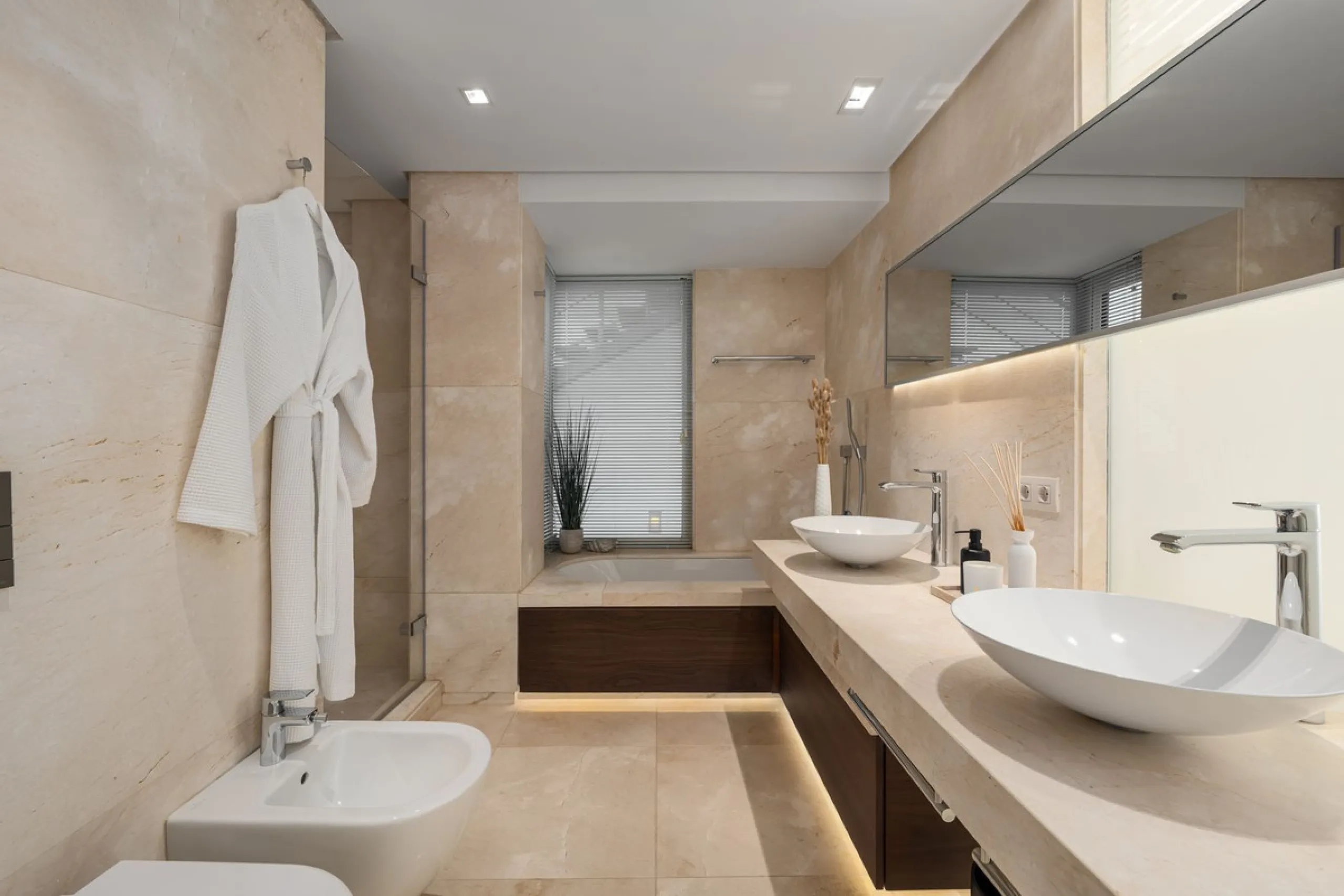 A semi-detached villa in the urbanisation, four bedrooms, four bathrooms, arranged with intent rather than habit: basement level below, an entrance floor with three en-suite bedrooms and a calm water feature setting the tone, a first floor dedicated entir