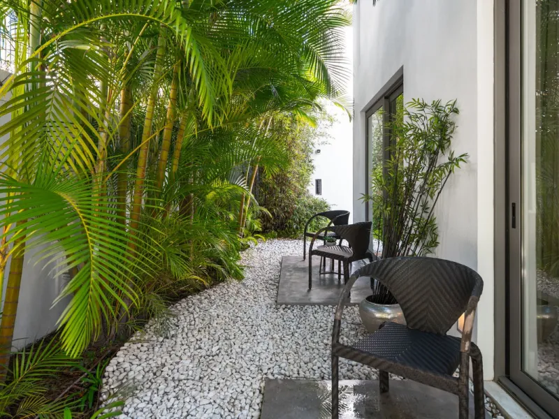 A semi-detached villa in the urbanisation, four bedrooms, four bathrooms, arranged with intent rather than habit: basement level below, an entrance floor with three en-suite bedrooms and a calm water feature setting the tone, a first floor dedicated entir