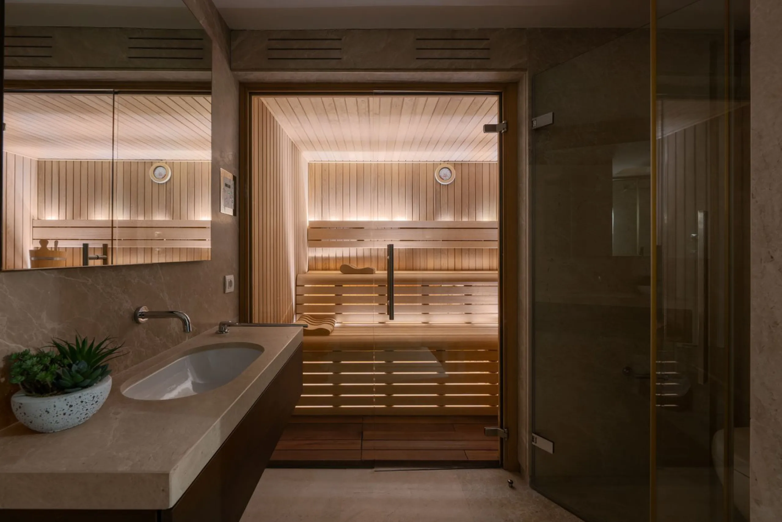 A semi-detached villa in the urbanisation, four bedrooms, four bathrooms, arranged with intent rather than habit: basement level below, an entrance floor with three en-suite bedrooms and a calm water feature setting the tone, a first floor dedicated entir