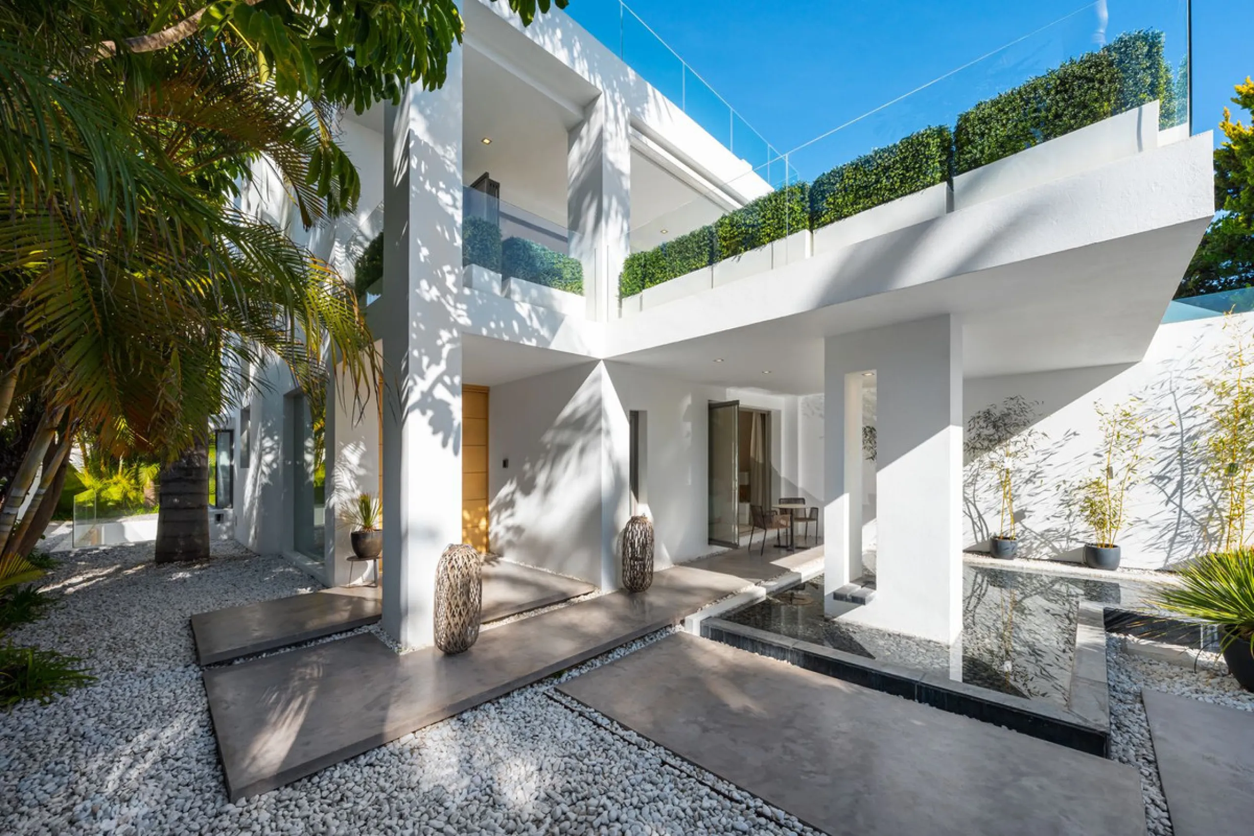 A semi-detached villa in the urbanisation, four bedrooms, four bathrooms, arranged with intent rather than habit: basement level below, an entrance floor with three en-suite bedrooms and a calm water feature setting the tone, a first floor dedicated entir