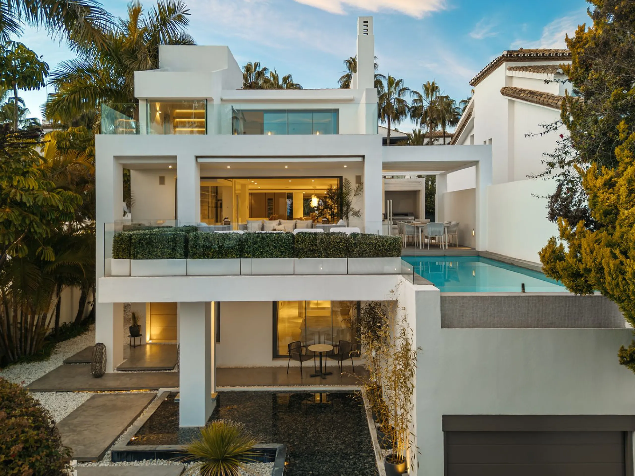 A semi-detached villa in the urbanisation, four bedrooms, four bathrooms, arranged with intent rather than habit: basement level below, an entrance floor with three en-suite bedrooms and a calm water feature setting the tone, a first floor dedicated entir