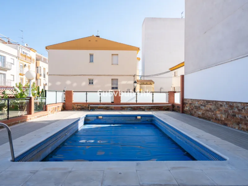 Discover a rare opportunity to own two beautifully designed homes combined on one generous plot in the heart of Vélez-Málaga — complete with private parking, a swimming pool, extensive entertainment areas, and a substantial commercial premise generating €