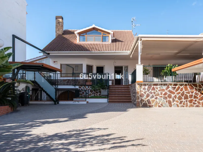 Discover a rare opportunity to own two beautifully designed homes combined on one generous plot in the heart of Vélez-Málaga — complete with private parking, a swimming pool, extensive entertainment areas, and a substantial commercial premise generating €