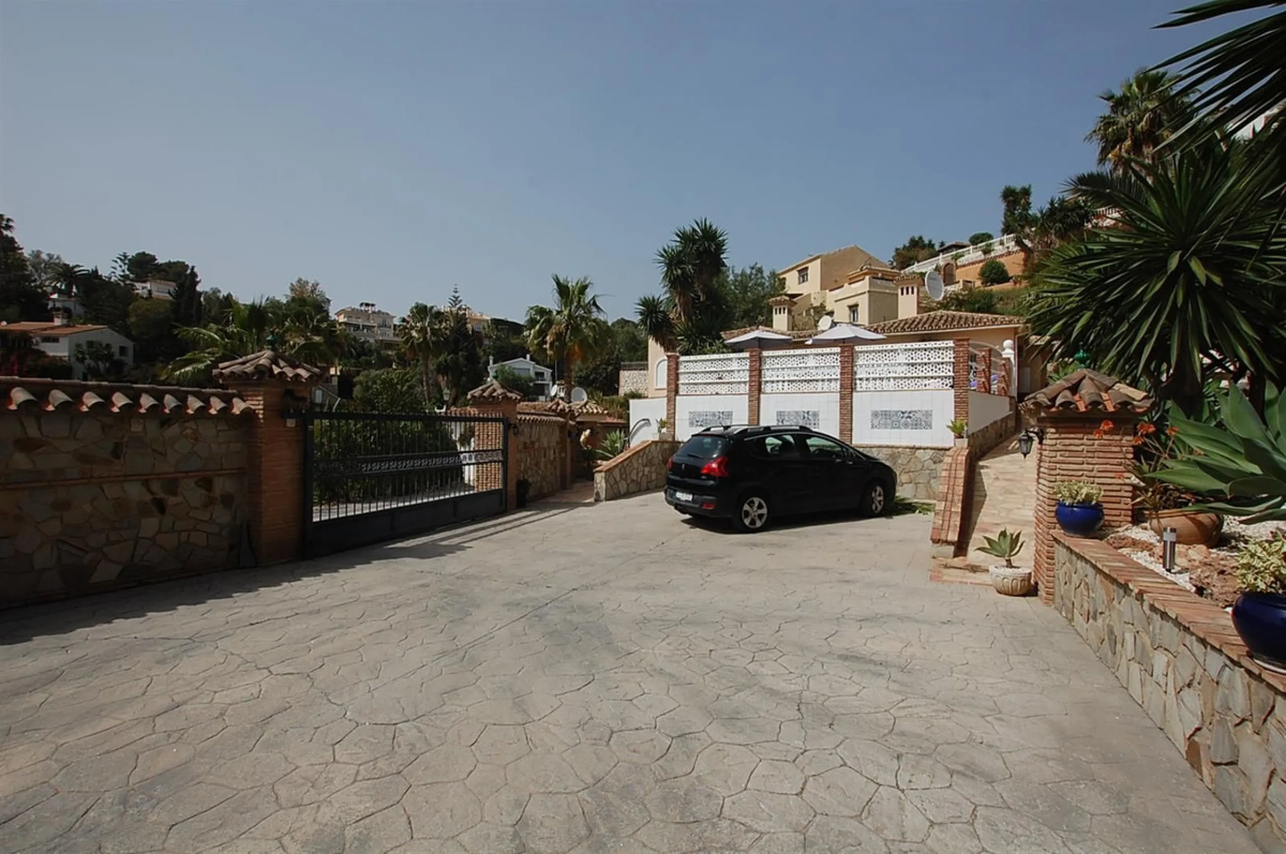 A large villa  in a quiet cul de sac in the Urbanisation of Campo Mijas with a large walled and gated garden with ample parking space for 3 or 4 cars . The property is entered via a gated entrance way to the large parking area with easy access to  the hou
