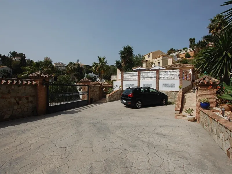 A large villa  in a quiet cul de sac in the Urbanisation of Campo Mijas with a large walled and gated garden with ample parking space for 3 or 4 cars . The property is entered via a gated entrance way to the large parking area with easy access to  the hou