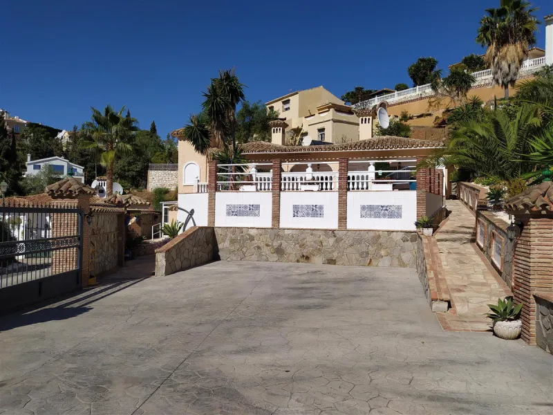 A large villa  in a quiet cul de sac in the Urbanisation of Campo Mijas with a large walled and gated garden with ample parking space for 3 or 4 cars . The property is entered via a gated entrance way to the large parking area with easy access to  the hou