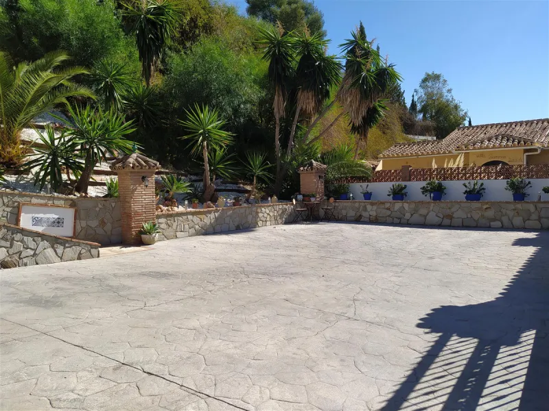 A large villa  in a quiet cul de sac in the Urbanisation of Campo Mijas with a large walled and gated garden with ample parking space for 3 or 4 cars . The property is entered via a gated entrance way to the large parking area with easy access to  the hou