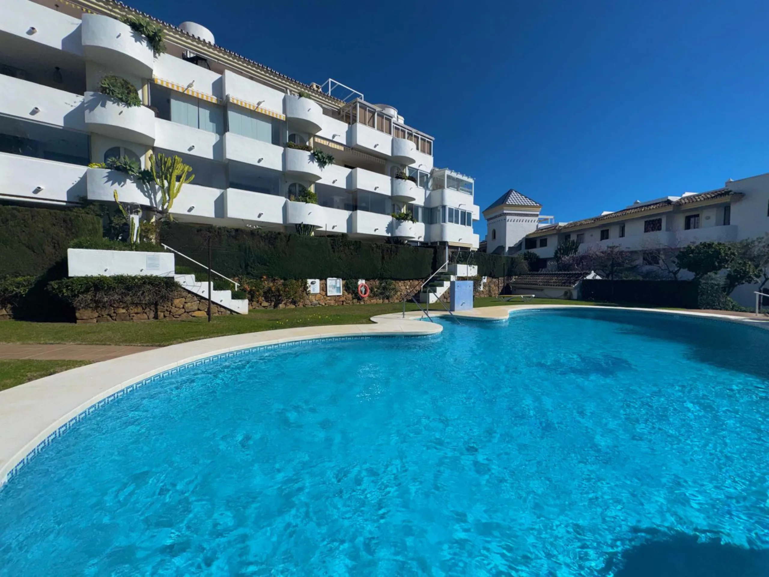 This fantastic two-bedroom, southwest-facing first-floor apartment in Calahonda offers beautiful sea views and an abundance of natural light throughout the day. The property features a bright and spacious living area complete with a charming fireplace, cr