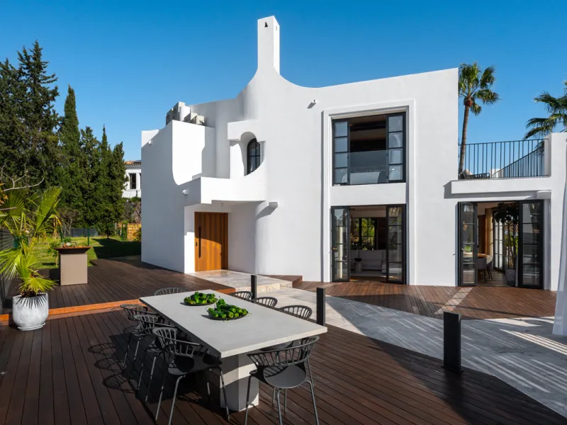 A four-bedroom villa in Nueva Andalucía with open golf and sea views, arranged over multiple levels with a garden-level pool, integrated outdoor kitchen, generous terraces and a private garage.
