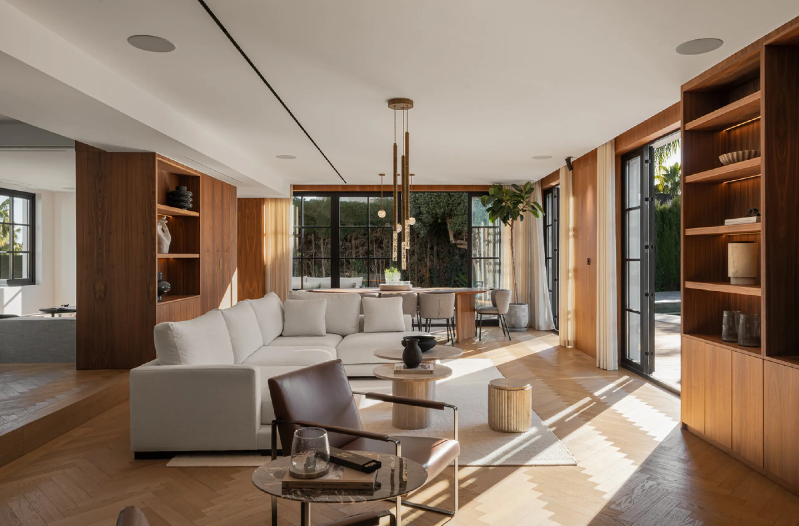 A four-bedroom villa in Nueva Andalucía with open golf and sea views, arranged over multiple levels with a garden-level pool, integrated outdoor kitchen, generous terraces and a private garage.