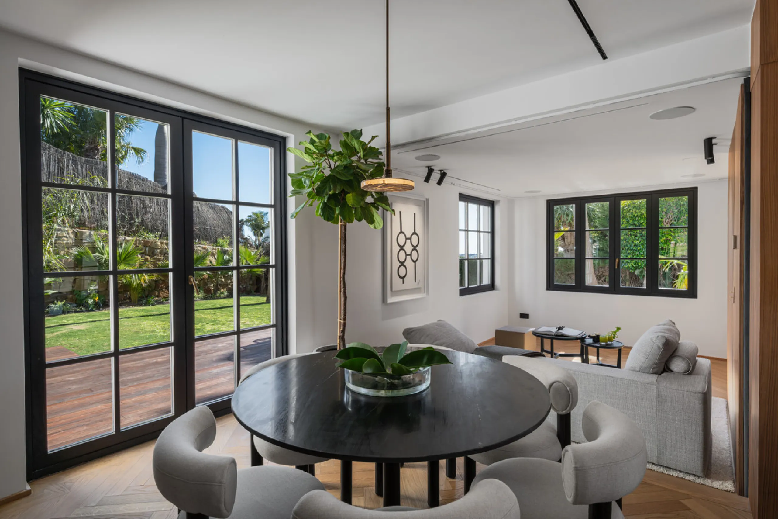 A four-bedroom villa in Nueva Andalucía with open golf and sea views, arranged over multiple levels with a garden-level pool, integrated outdoor kitchen, generous terraces and a private garage.