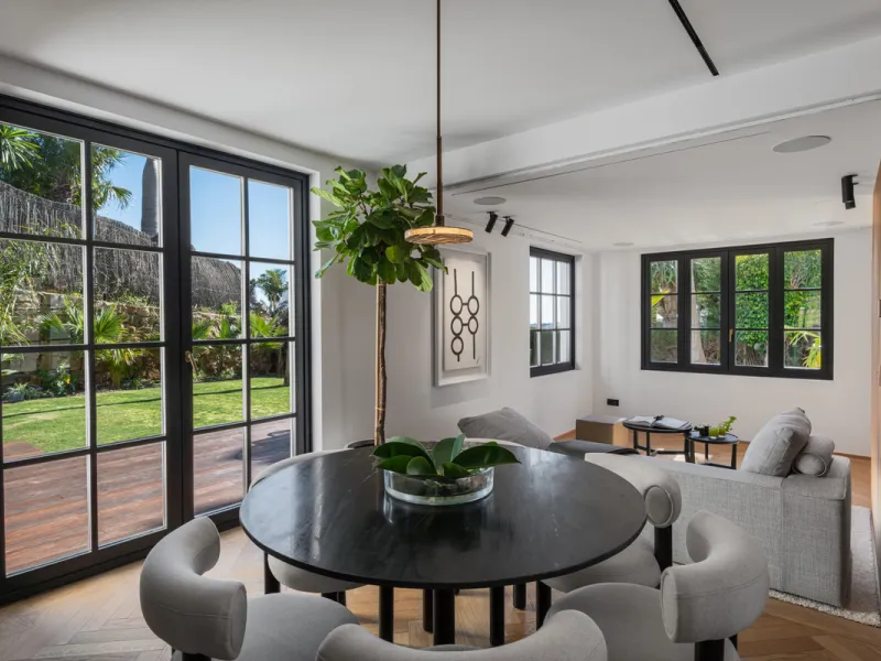 A four-bedroom villa in Nueva Andalucía with open golf and sea views, arranged over multiple levels with a garden-level pool, integrated outdoor kitchen, generous terraces and a private garage.