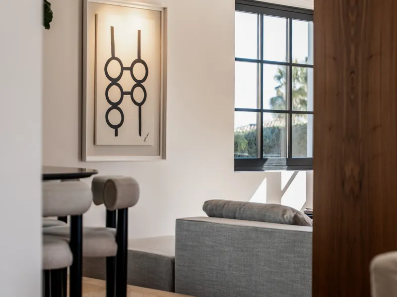 A four-bedroom villa in Nueva Andalucía with open golf and sea views, arranged over multiple levels with a garden-level pool, integrated outdoor kitchen, generous terraces and a private garage.