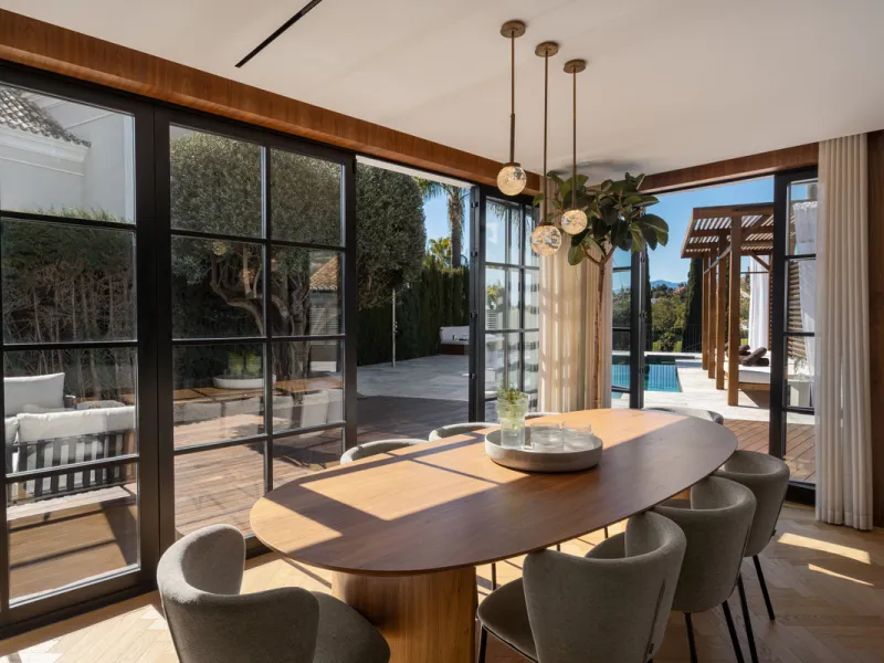 A four-bedroom villa in Nueva Andalucía with open golf and sea views, arranged over multiple levels with a garden-level pool, integrated outdoor kitchen, generous terraces and a private garage.