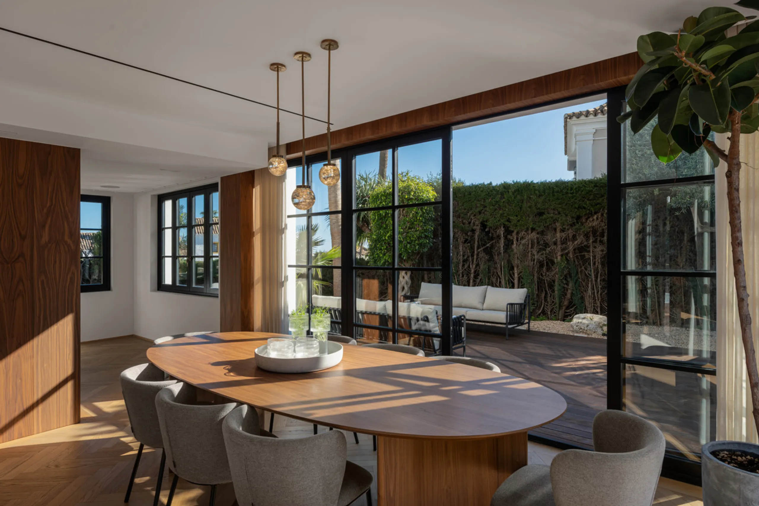A four-bedroom villa in Nueva Andalucía with open golf and sea views, arranged over multiple levels with a garden-level pool, integrated outdoor kitchen, generous terraces and a private garage.