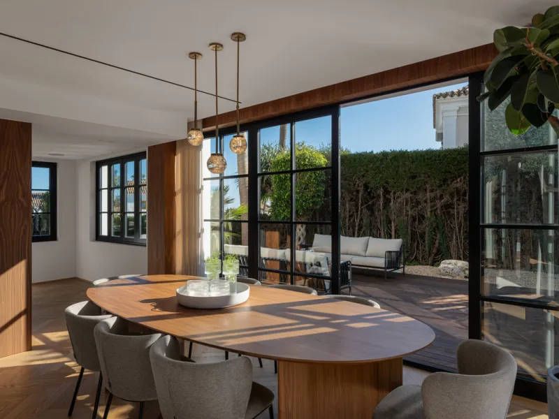 A four-bedroom villa in Nueva Andalucía with open golf and sea views, arranged over multiple levels with a garden-level pool, integrated outdoor kitchen, generous terraces and a private garage.