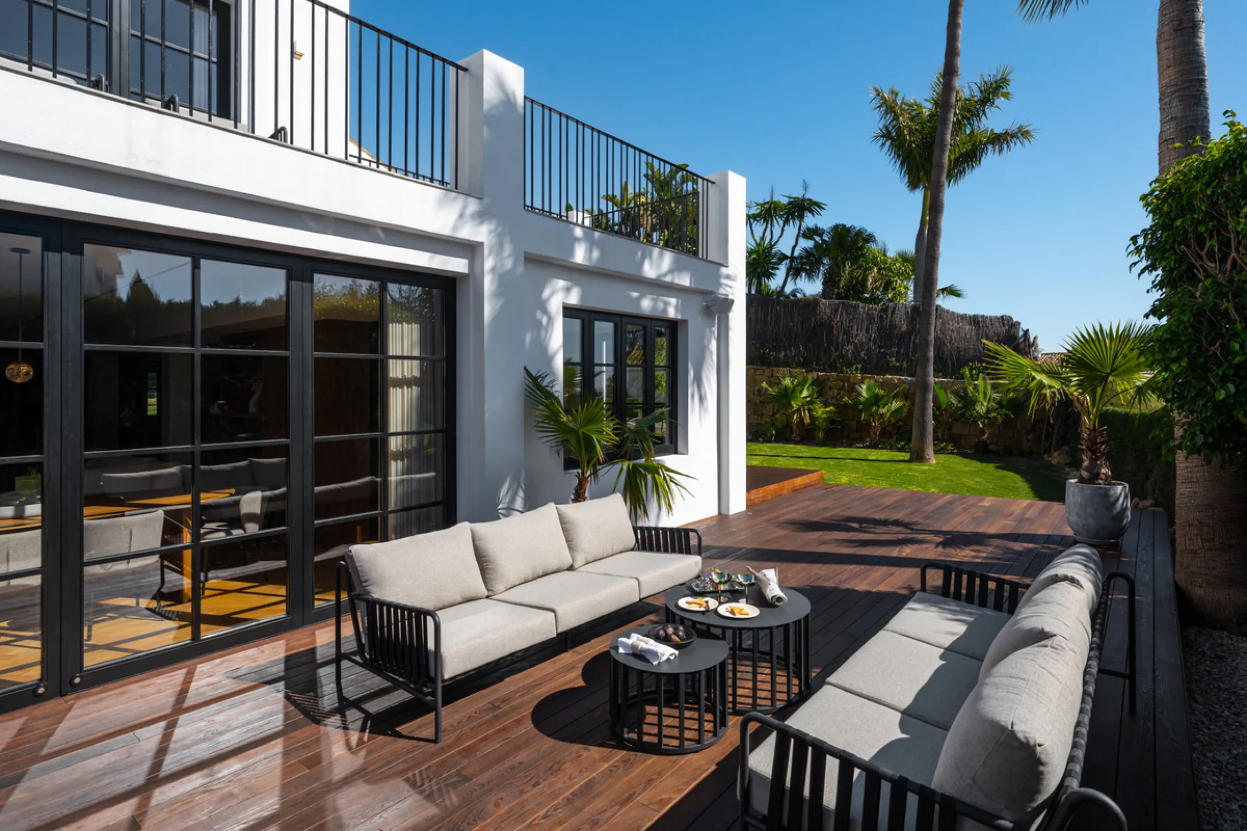 A four-bedroom villa in Nueva Andalucía with open golf and sea views, arranged over multiple levels with a garden-level pool, integrated outdoor kitchen, generous terraces and a private garage.