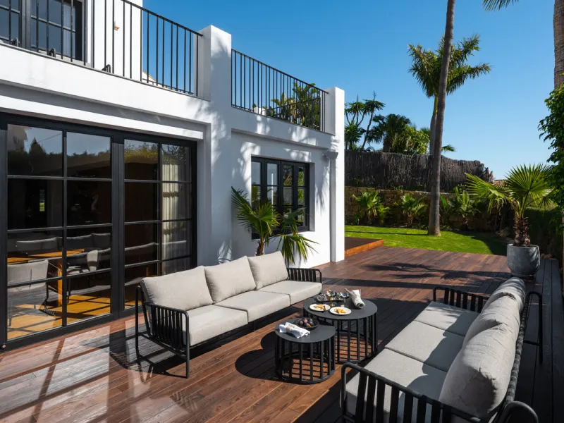 A four-bedroom villa in Nueva Andalucía with open golf and sea views, arranged over multiple levels with a garden-level pool, integrated outdoor kitchen, generous terraces and a private garage.
