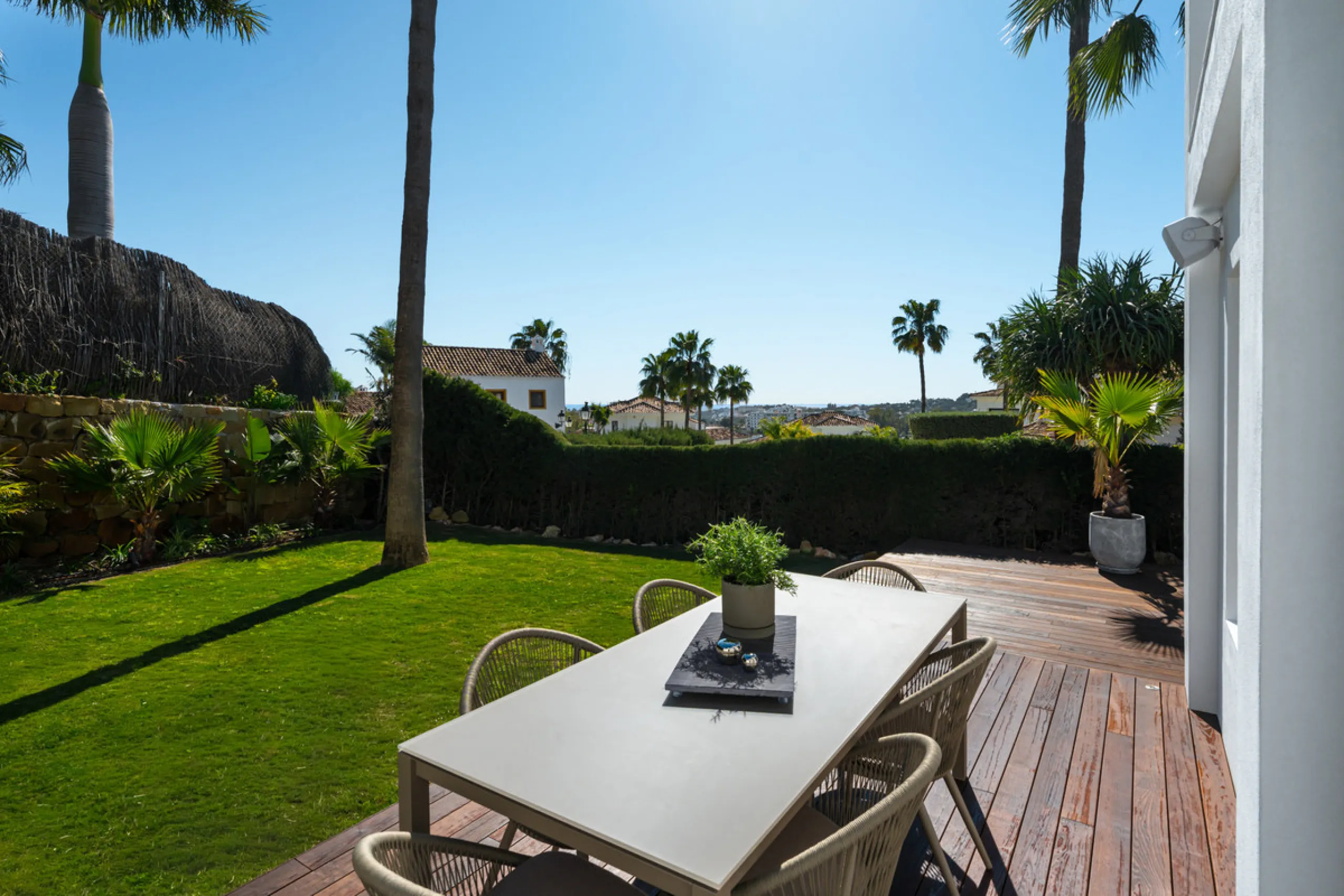 A four-bedroom villa in Nueva Andalucía with open golf and sea views, arranged over multiple levels with a garden-level pool, integrated outdoor kitchen, generous terraces and a private garage.