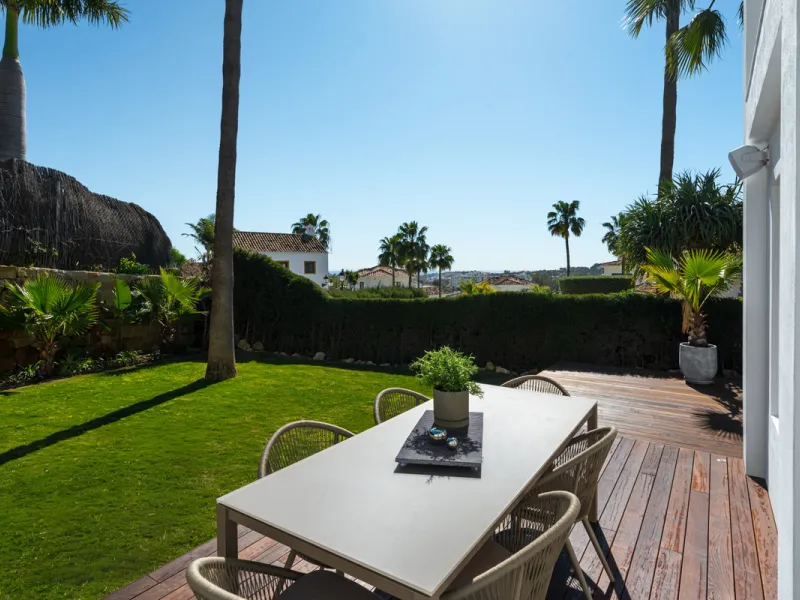 A four-bedroom villa in Nueva Andalucía with open golf and sea views, arranged over multiple levels with a garden-level pool, integrated outdoor kitchen, generous terraces and a private garage.