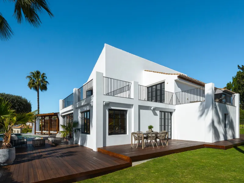 A four-bedroom villa in Nueva Andalucía with open golf and sea views, arranged over multiple levels with a garden-level pool, integrated outdoor kitchen, generous terraces and a private garage.