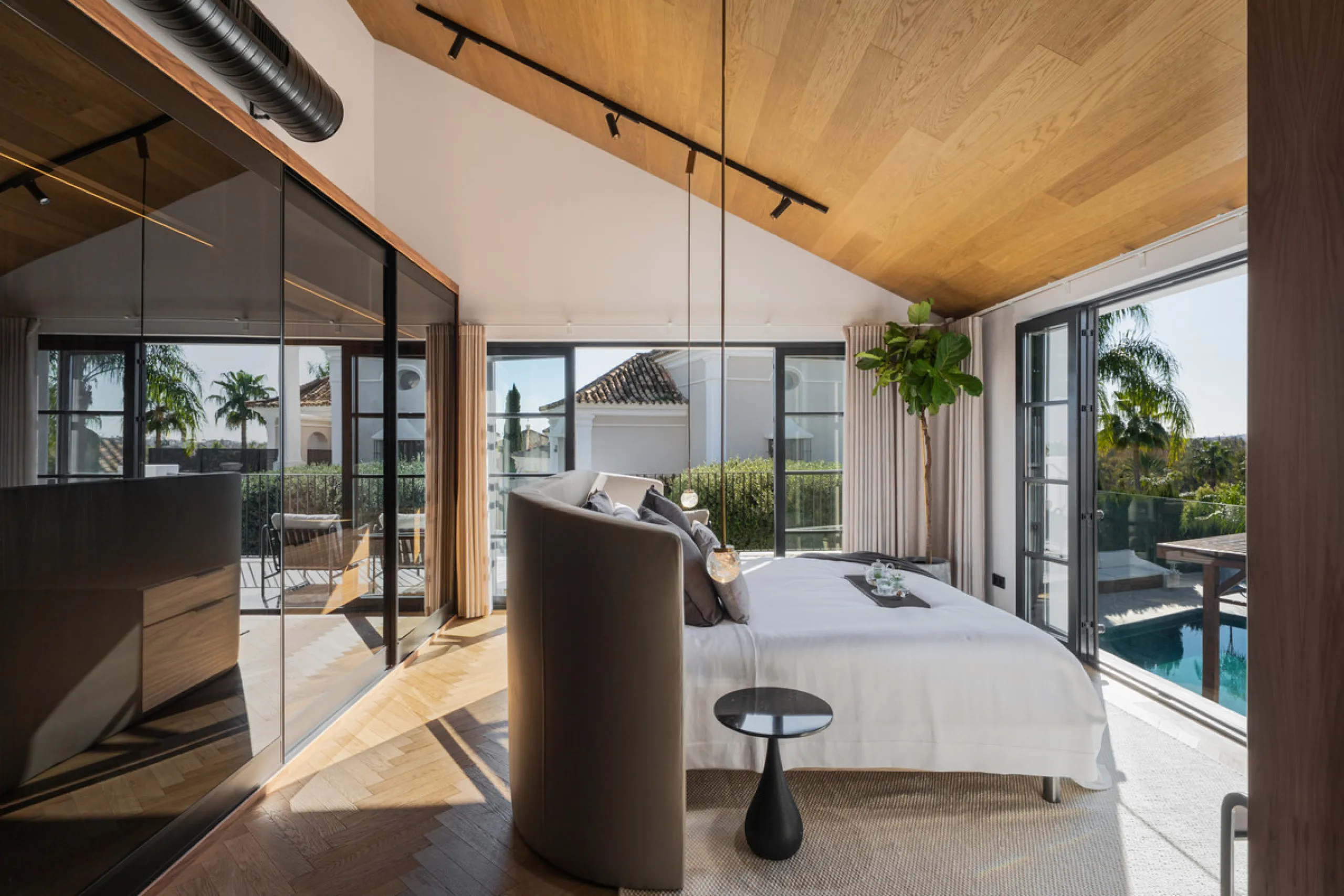A four-bedroom villa in Nueva Andalucía with open golf and sea views, arranged over multiple levels with a garden-level pool, integrated outdoor kitchen, generous terraces and a private garage.
