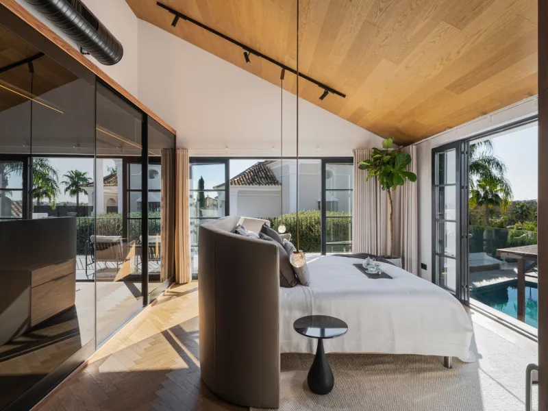 A four-bedroom villa in Nueva Andalucía with open golf and sea views, arranged over multiple levels with a garden-level pool, integrated outdoor kitchen, generous terraces and a private garage.