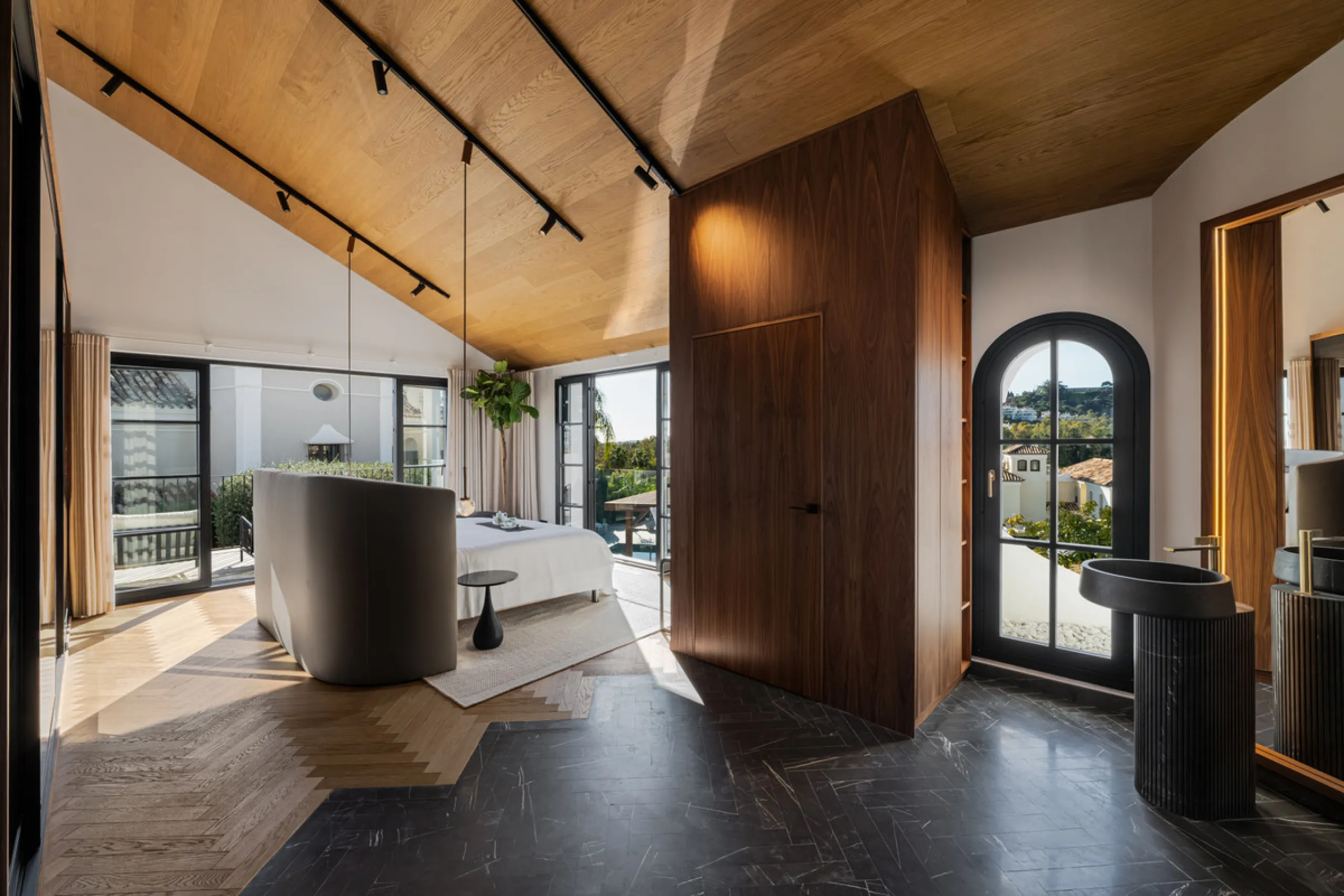 A four-bedroom villa in Nueva Andalucía with open golf and sea views, arranged over multiple levels with a garden-level pool, integrated outdoor kitchen, generous terraces and a private garage.