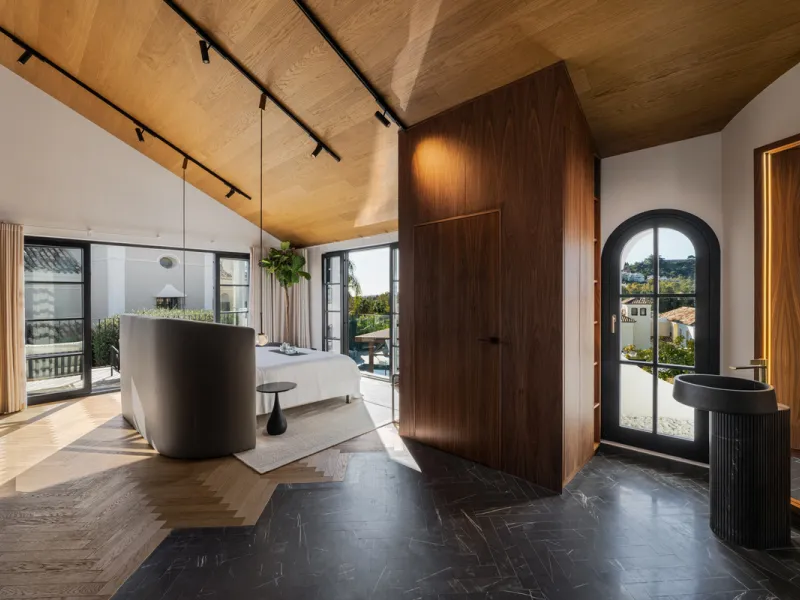 A four-bedroom villa in Nueva Andalucía with open golf and sea views, arranged over multiple levels with a garden-level pool, integrated outdoor kitchen, generous terraces and a private garage.